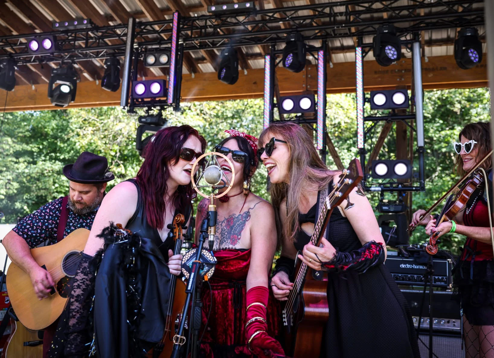 Jenny singing beside the fiddle player on an outdoor stage