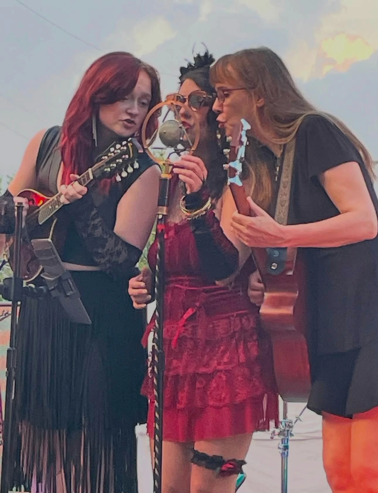 Three StreetWalkers singing together around a shared microphone